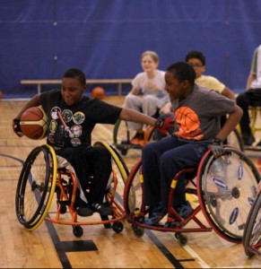 Two young boys playing Wheelchair basketball