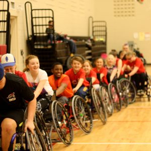 wheelchair athletes towing each other in a line